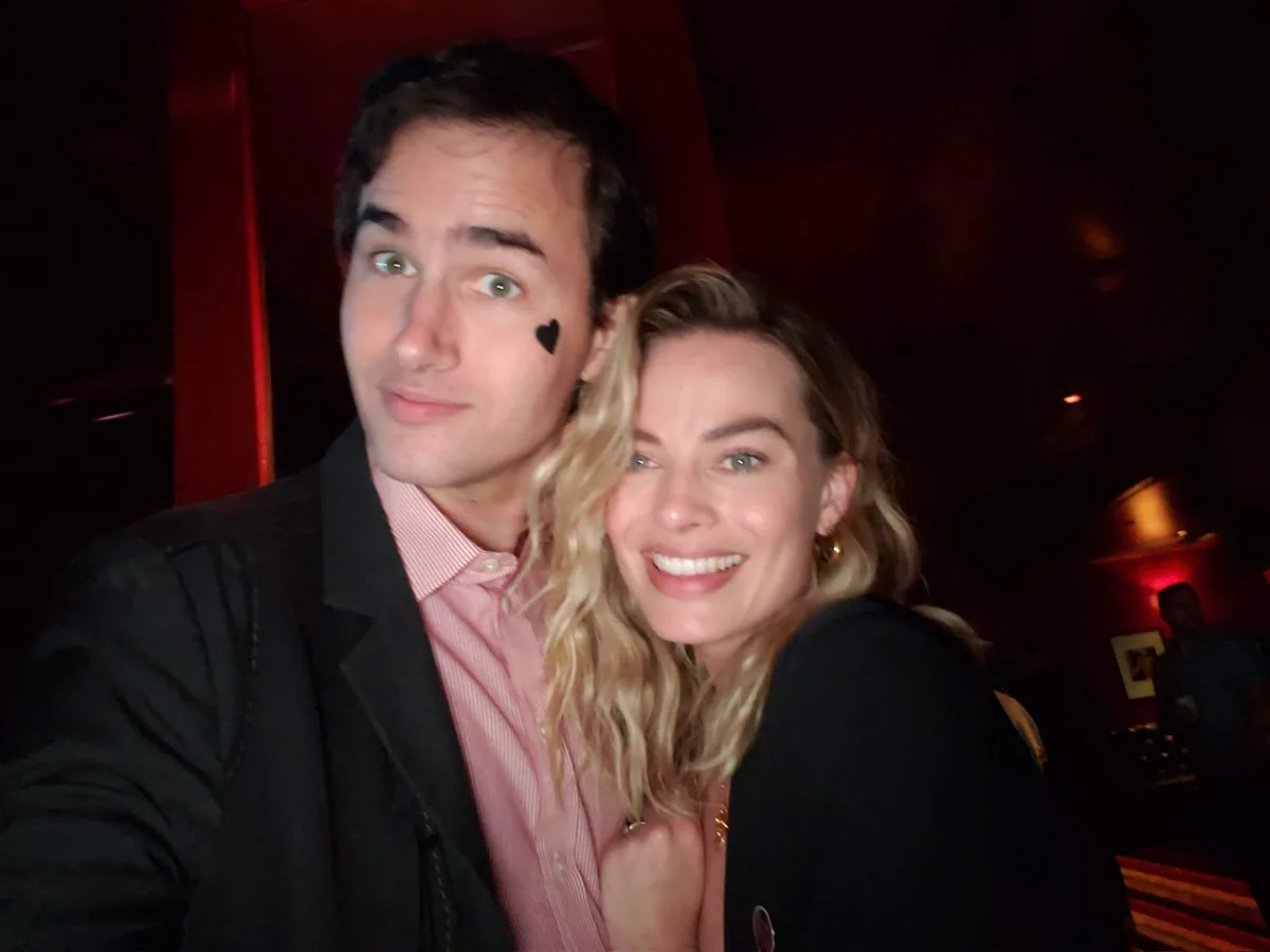 Roby Sobieski demonstrating sleight of hand for Margot Robbie
